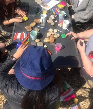 SAHSH young people decorate beach pebbles with messages of positivity with paints and pens
